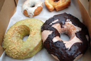 Four different donuts sit next to each other in a box